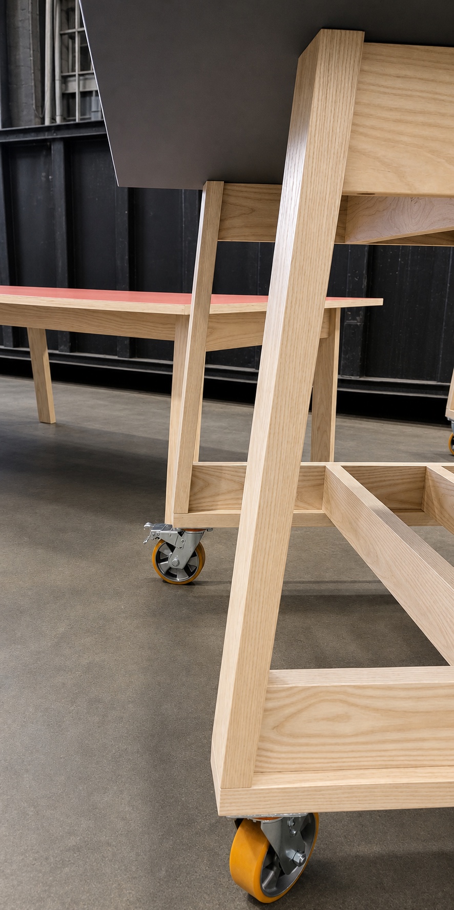 Close view of a rolling modular work surface frame and caster
